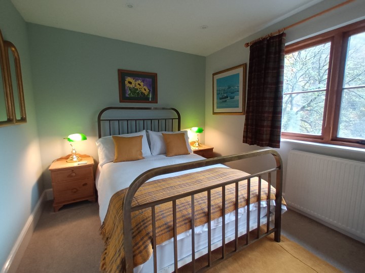 Bright double bedroom looking out over the forest and hills.